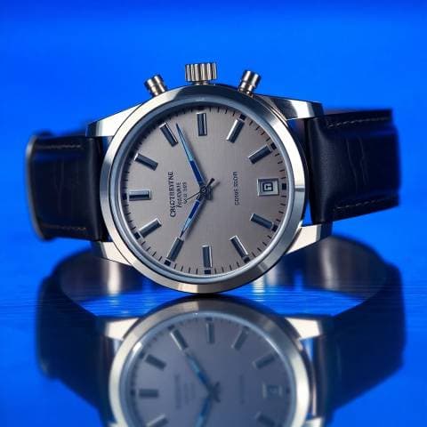 Mechanical wristwatch on brushed steel, macro shot, cold blue key light, crisp reflections, luxury catalogue photography